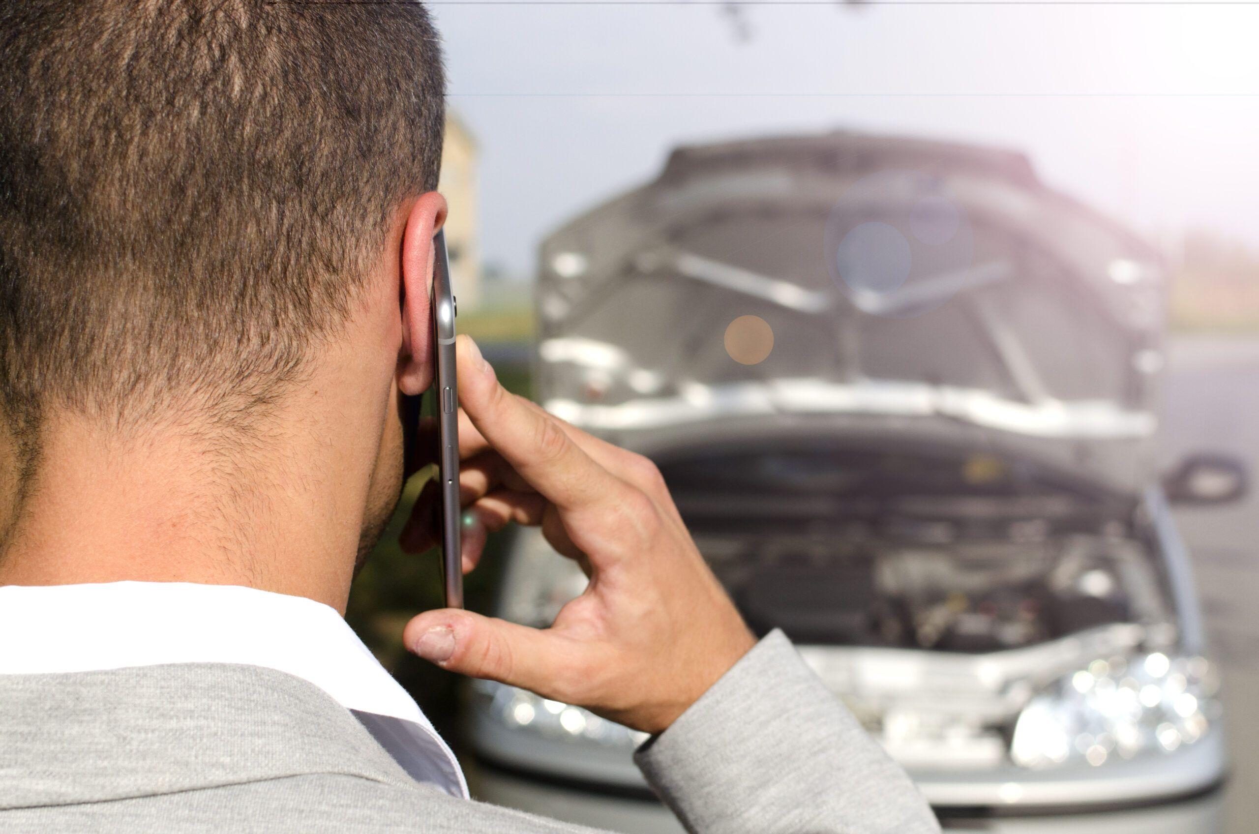 hombre pie junto al vehiculo roto llamando al servicio remolque